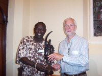 Zakari presents a beautiful ebony carving, a CIWARA, to the Chair of Burley Parish Council